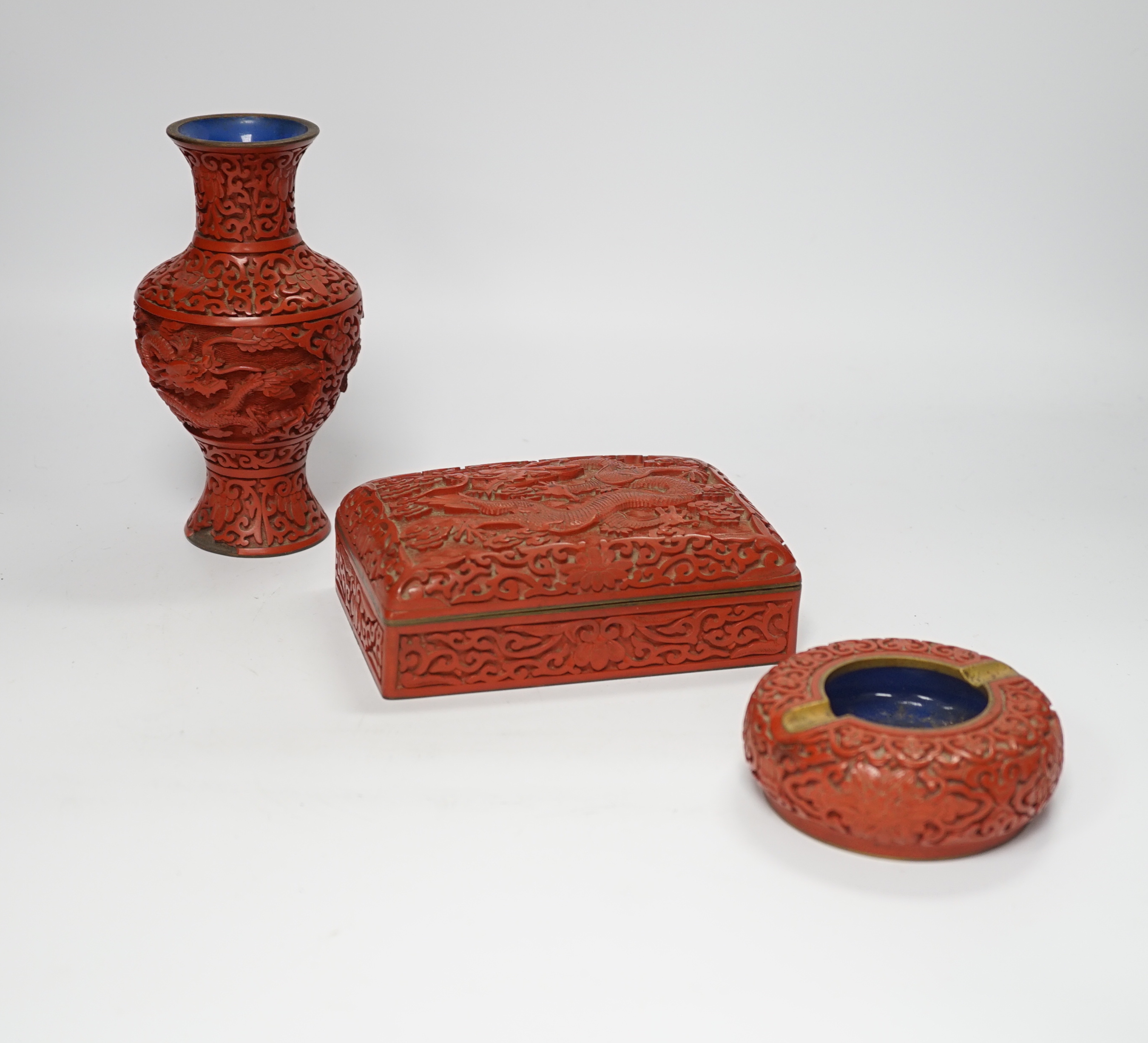 Three Chinese cinnabar lacquer items, a vase, an ashtray and a lidded box, vase 16.5cm